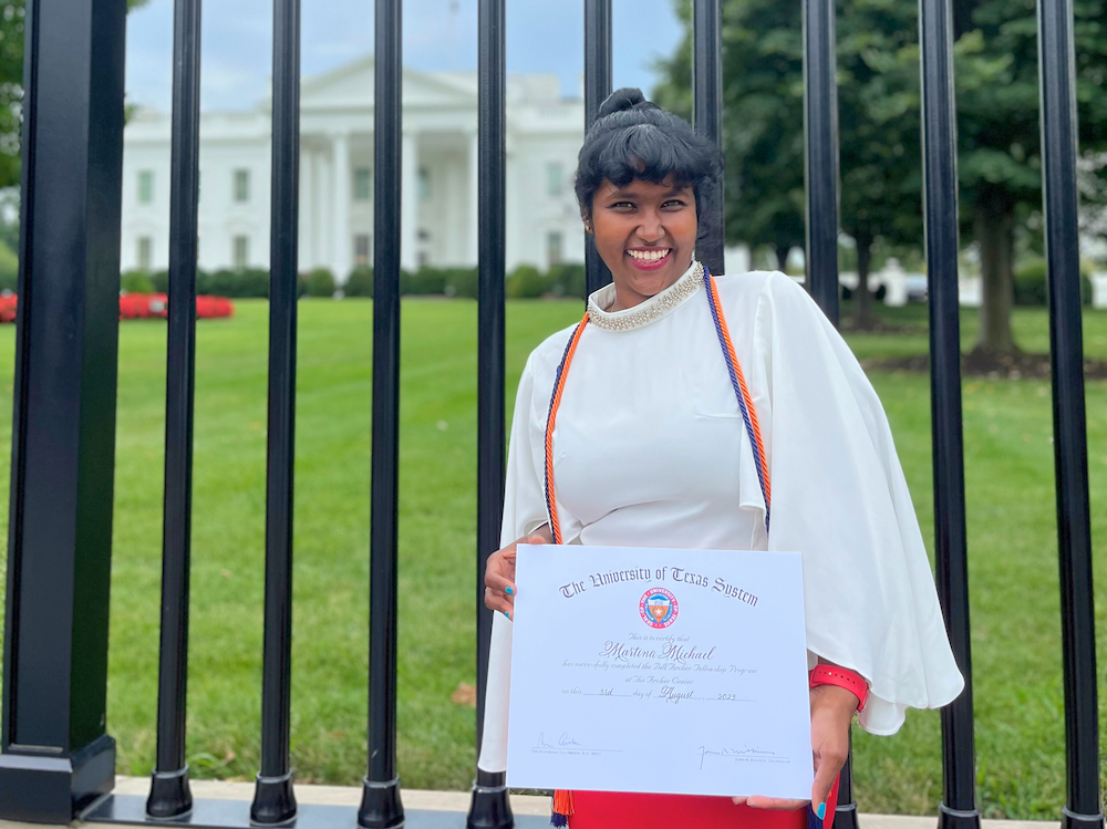Alumna holding Archer Fellowship certificate